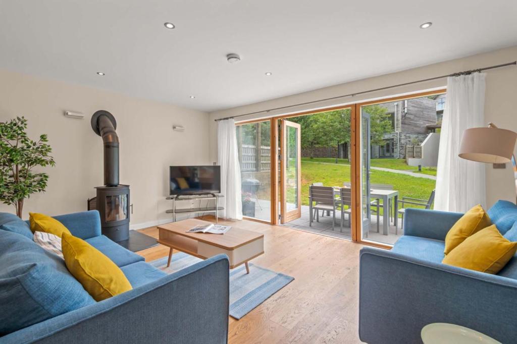 a living room with a blue couch and a fireplace at House 3 in Looe