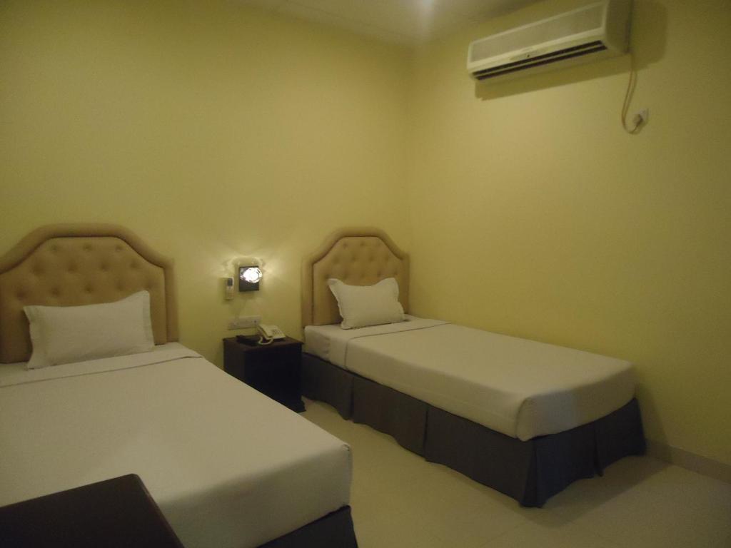 a room with two beds and a air conditioner at Executive Residence in Chittagong