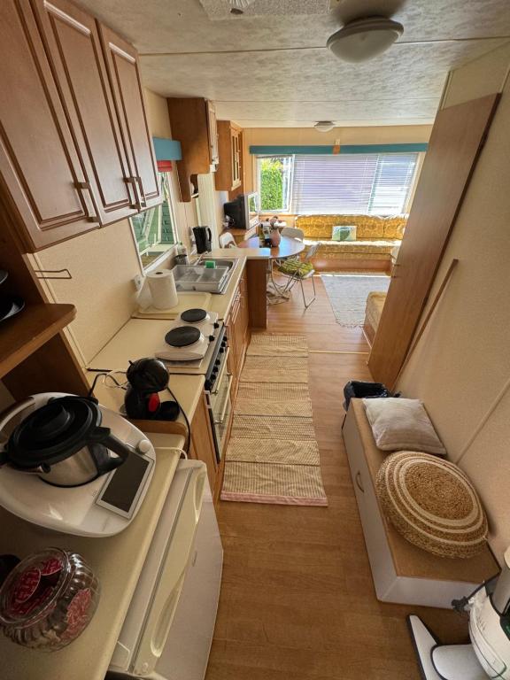 mała kuchnia z białymi urządzeniami i dużym oknem w obiekcie Mandala Mielno Camping w mieście Mielno