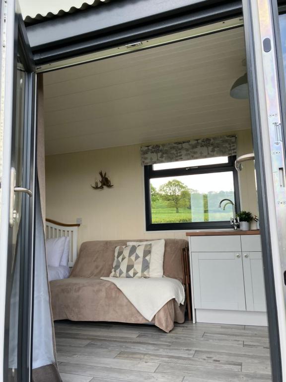 a bedroom in a tiny house with a bed and a window at Ribble Valley Retreat in Langho