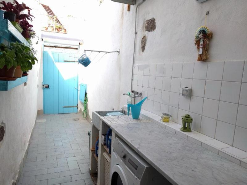 een keuken met een wastafel en een blauwe deur bij A Casa di Carla - Tiny House in SantʼAntìoco