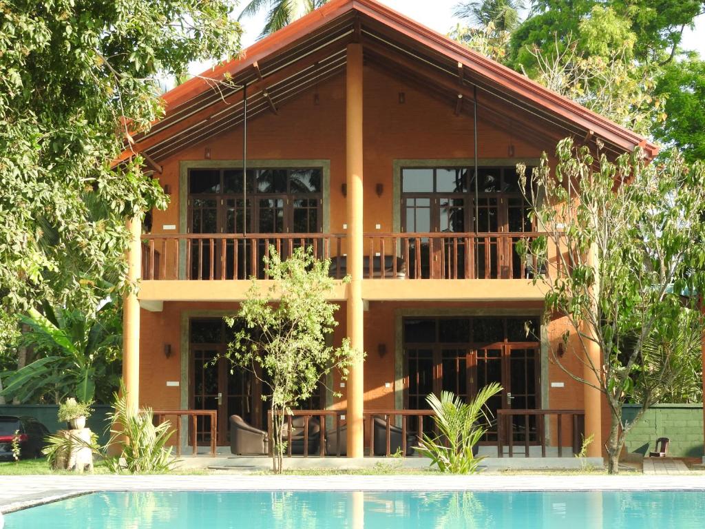 a house with a pool in front of it at The Grand Yala Hotel in Tissamaharama