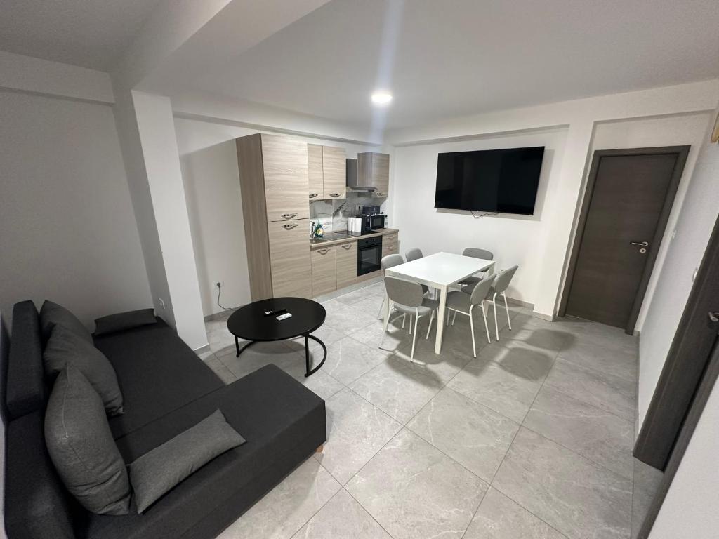 a living room with a couch and a table and a kitchen at Apartments Portéa - NEW 2025 in Izola