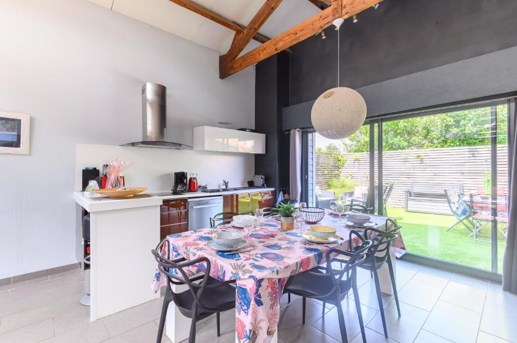 une cuisine avec une table et des chaises dans une cuisine dans l'établissement Le Loft Sablais, 3 étoiles de l'Office de Tourisme, à Les Sables-dʼOlonne