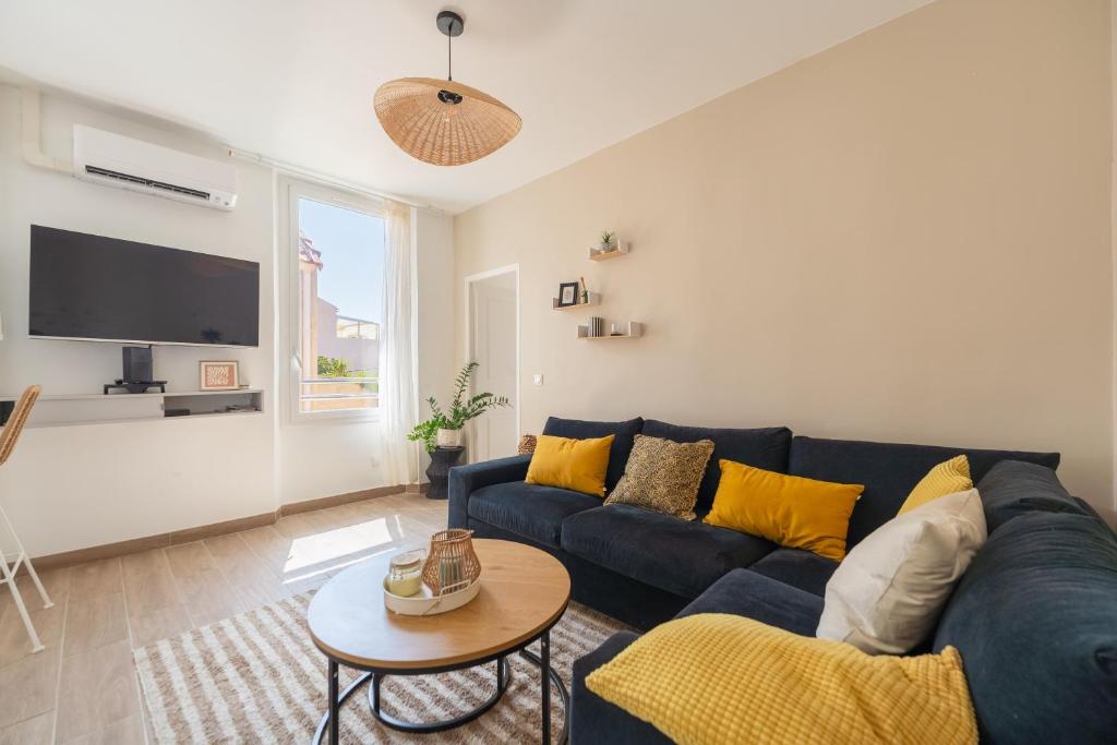a living room with a blue couch and a tv at Bandol - Appartement Corneille in Bandol