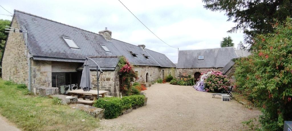 - un vieux bâtiment en pierre avec une table de pique-nique devant dans l'établissement Jonael, à Scrignac