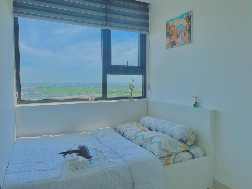 un lit dans une chambre avec une grande fenêtre dans l'établissement Cố Đô Homestay, à Thôn Văn Dương