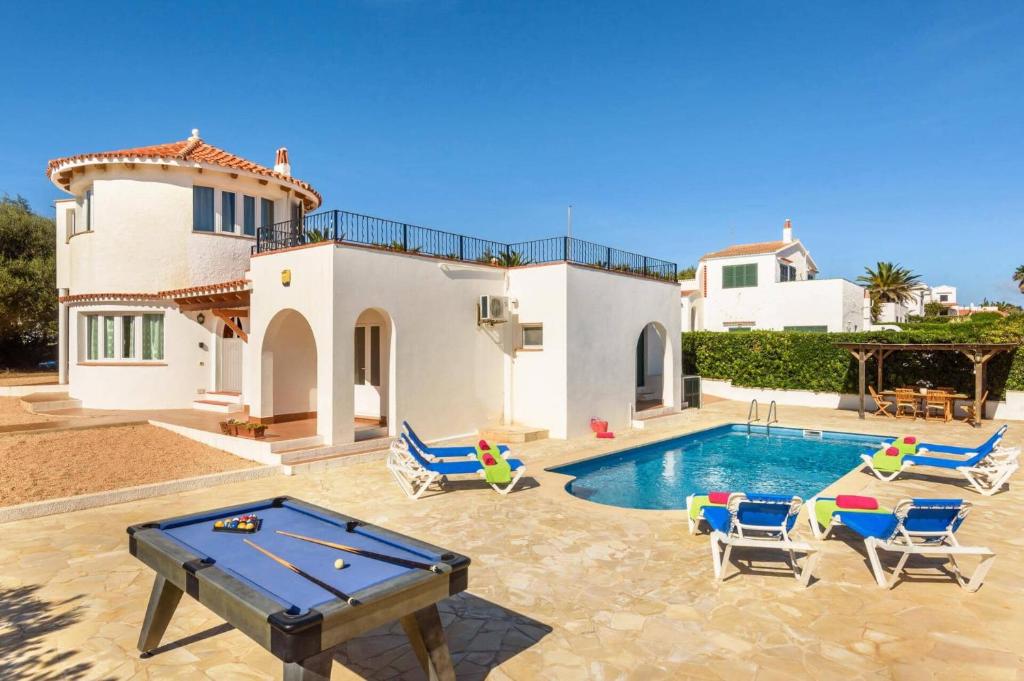 a villa with a pool with chairs and a pool table at Villa Claudia by Villa Plus in S'Algar