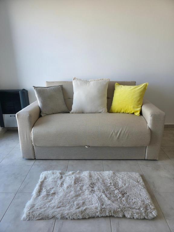 eine Couch mit zwei Kissen und einem Teppich in einem Wohnzimmer in der Unterkunft Moderno y equipado Departamento - Viedma in Viedma