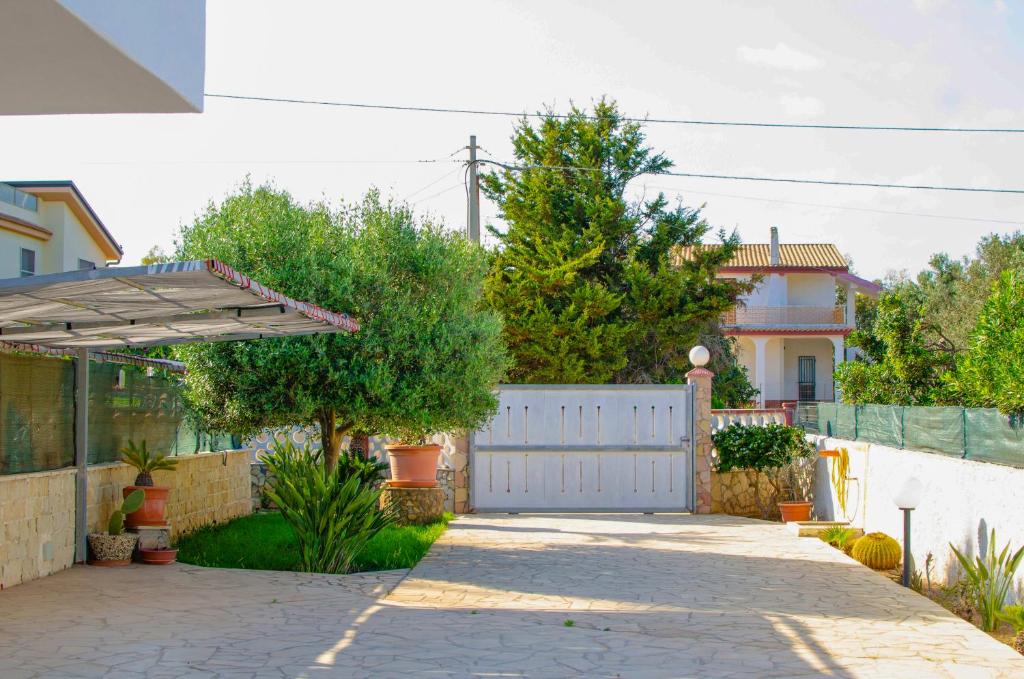 a house with a white fence and a driveway at San Lorenzo Holiday in San Lorenzo