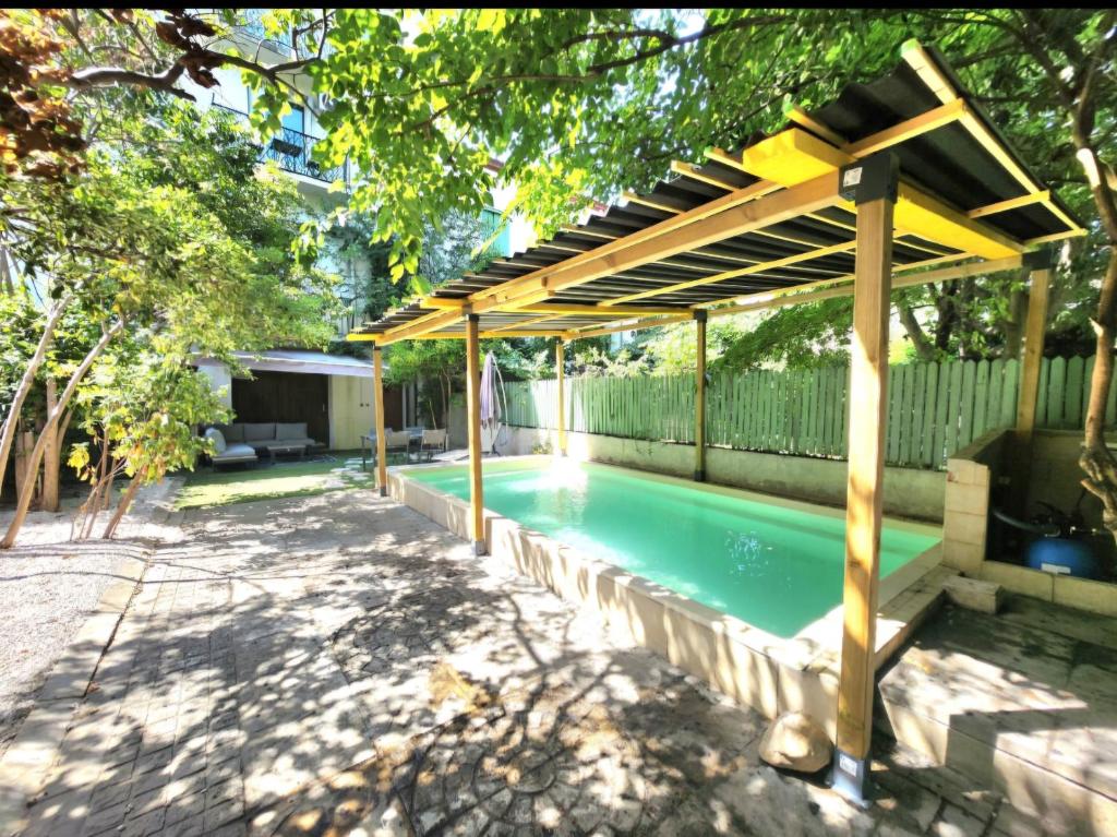 - une piscine avec pergola à côté d'une maison dans l'établissement Appartement détente avec jacuzzi et piscine, à Perpignan