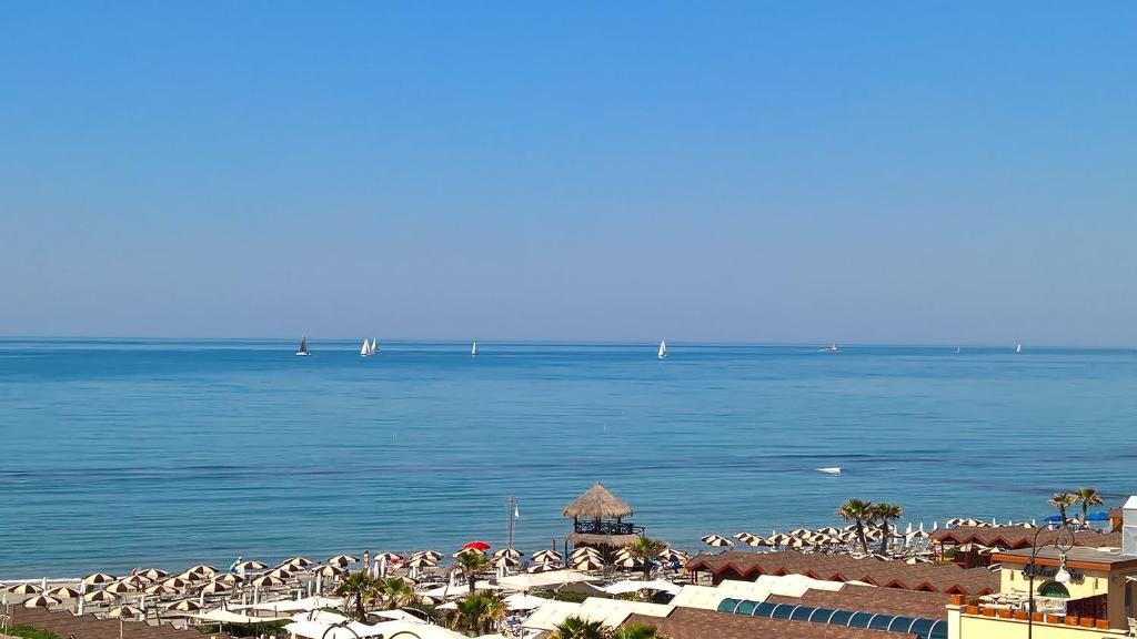 una playa con un montón de sillas y el océano en Hotel La Scaletta, en Lido di Ostia