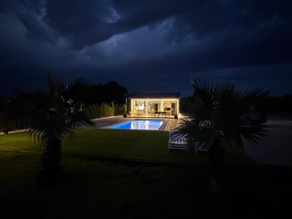 una casa con piscina por la noche en Villa Oasis, en Albacete