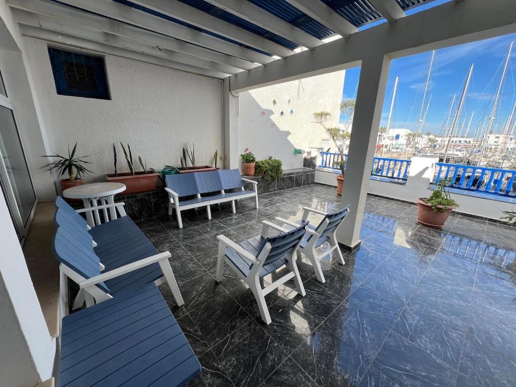 a patio with chairs and a table and a balcony at Monastir duplex with terrace in the marina in Monastir
