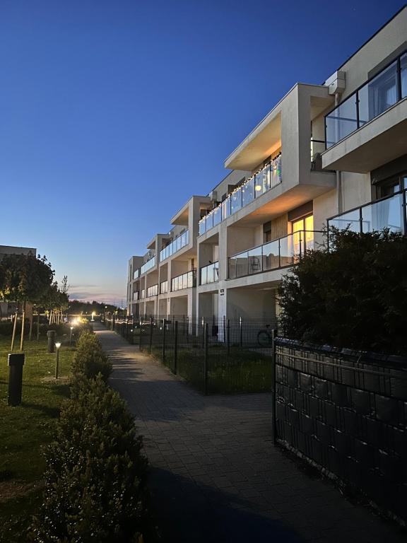 duży budynek apartamentowy z chodnikiem przed nim w obiekcie Apartament Premium w mieście Słupsk