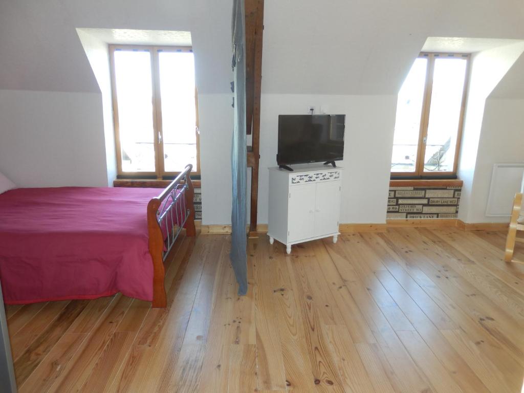 MarcenatにあるLa Maison en Cézallier - London Eyesのベッドと薄型テレビのある寝室