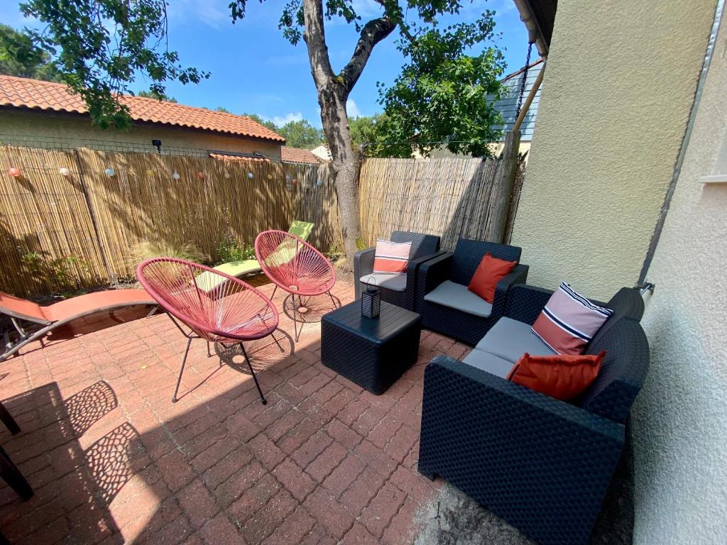 d'une terrasse meublée avec une table et des chaises. dans l'établissement Agréable maison rénovée, à Lacanau-Océan