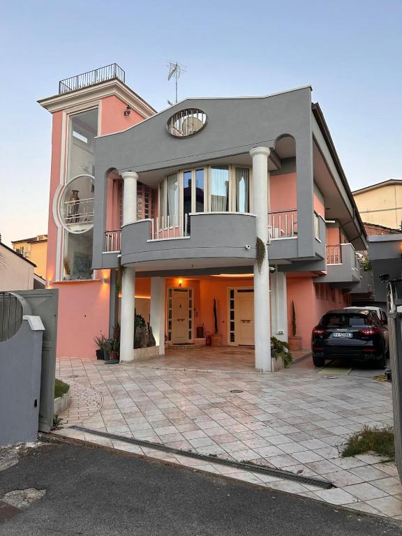 a pink house with a car parked in front of it at B&B Villa Pina in Colleferro