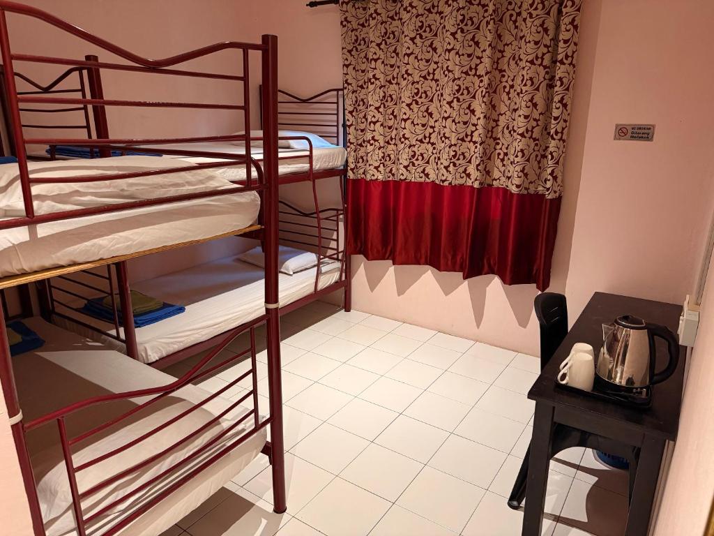 a room with two bunk beds and a table and a window at RTMS Guesthouse Semporna in Semporna