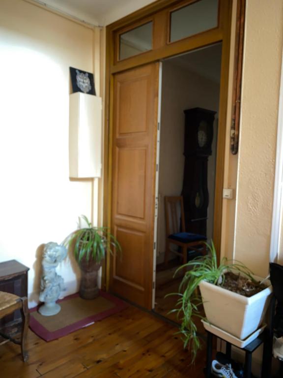 une pièce avec une porte, des plantes et une horloge dans l'établissement La chambre Terra Cotta, à La Celle-sous-Gouzon