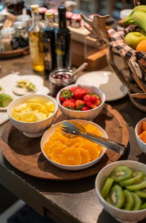 a table topped with bowls of fruit and bowls of vegetables at La Genzianella Bormio in Bormio