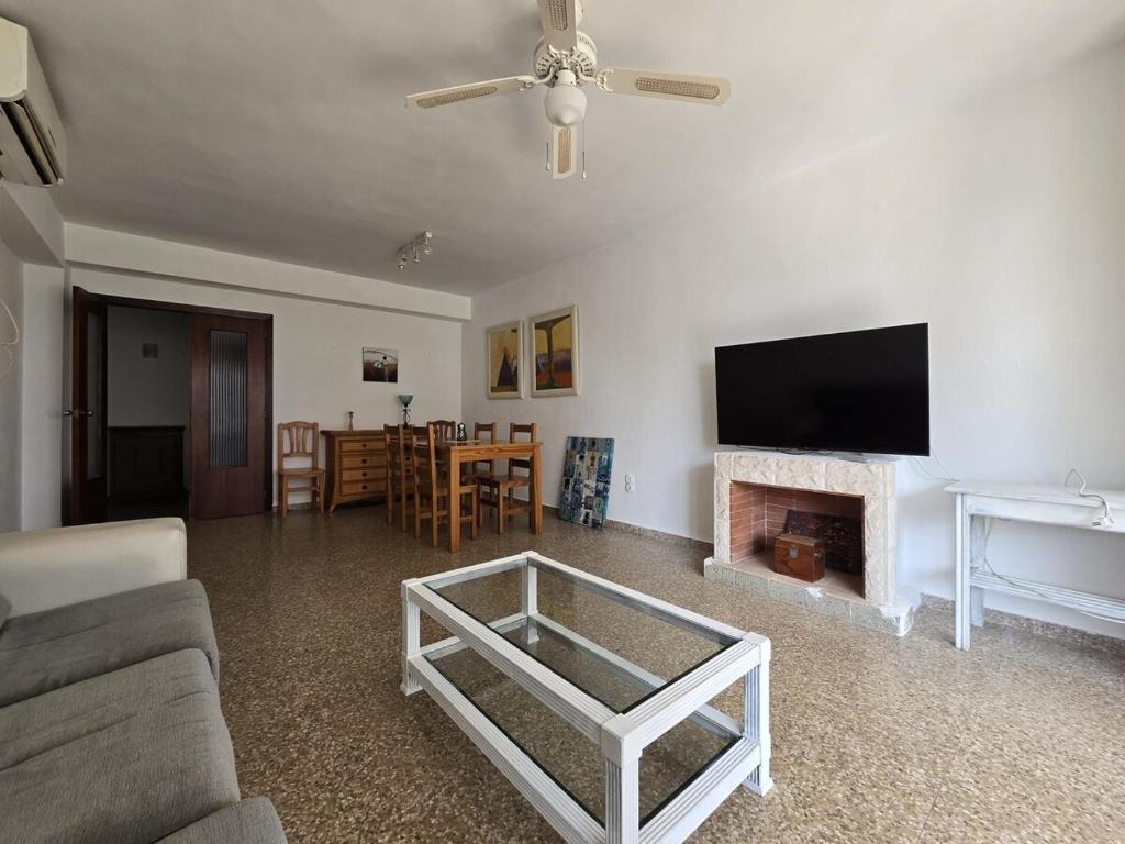 ein Wohnzimmer mit einem Sofa, einem TV und einem Kamin in der Unterkunft Apartamento Playa de Gandia in Puerto de Gandía