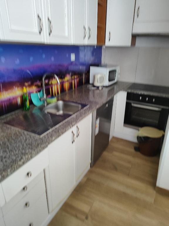 una cocina con fregadero y microondas en Apartmani Prestige, en Baška Voda