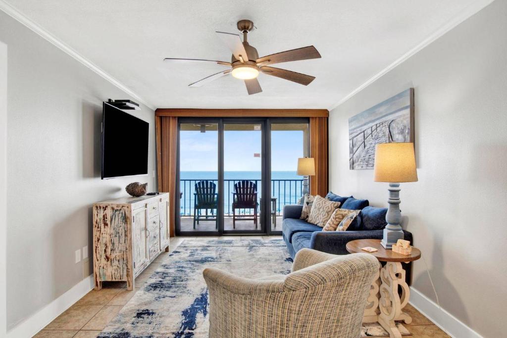 a living room with a blue couch and a tv at Phoenix II 2062 in Romar Beach