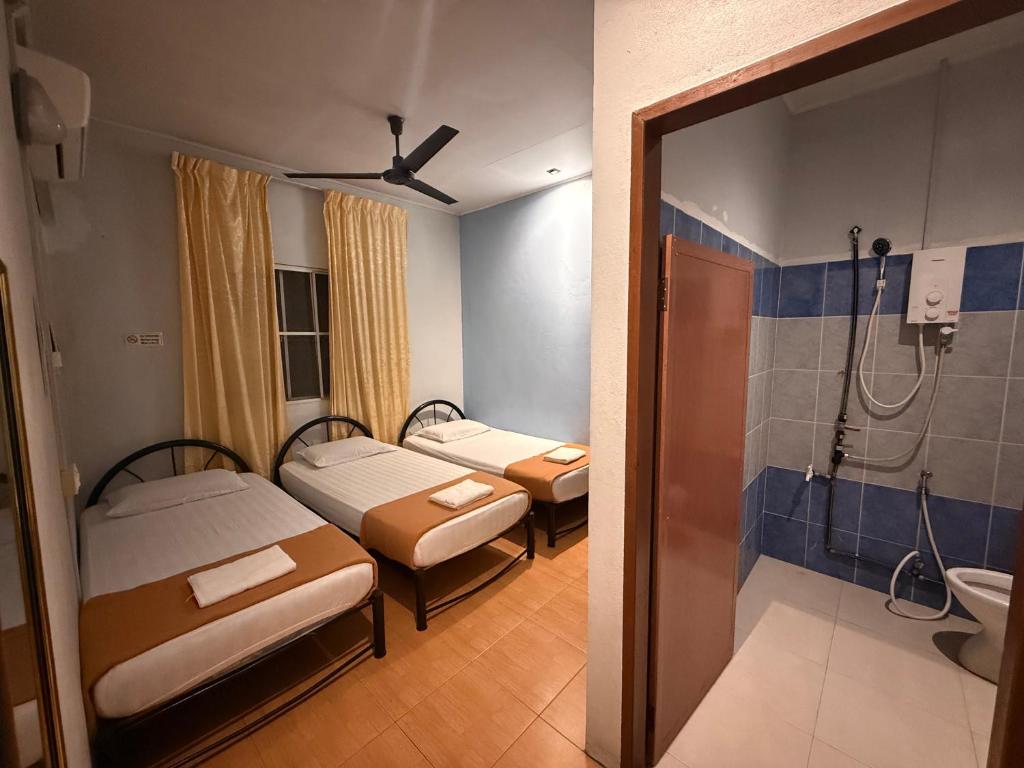 a hospital room with two beds and a shower at RTMS Guesthouse Semporna in Semporna