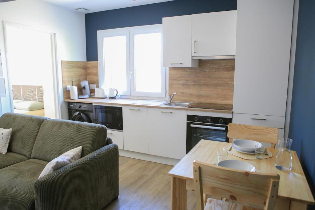 a kitchen with a couch and a table in a room at Superbe apartement T2 in La Celle-sous-Gouzon