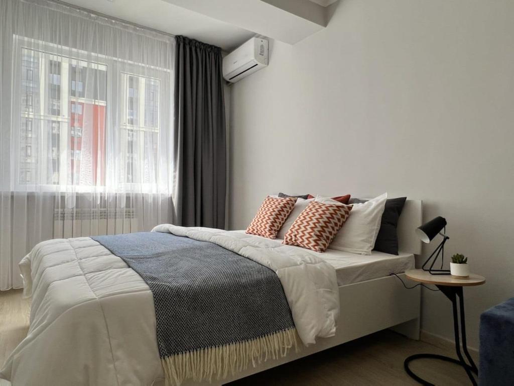 アルマトイにあるЖК Молодежныйのベッドルーム1室(枕付きのベッド1台、窓付)