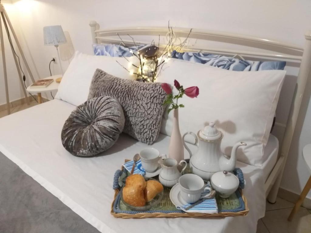 a tray with a tea set on a bed at Adelia's Luxury Studio in Corfu in Corfu