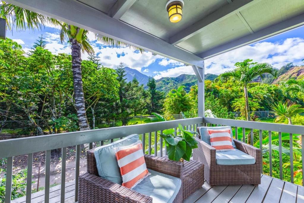 a porch with wicker chairs and a view of the mountains at Hale Kanani (Kaua'i) TVNC 1342 in Hanalei