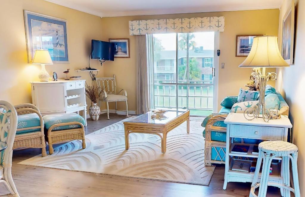 un soggiorno con un divano e un tavolo di Cozy condo with balcony, walking distance to conch house and WIFI a Davis Shores