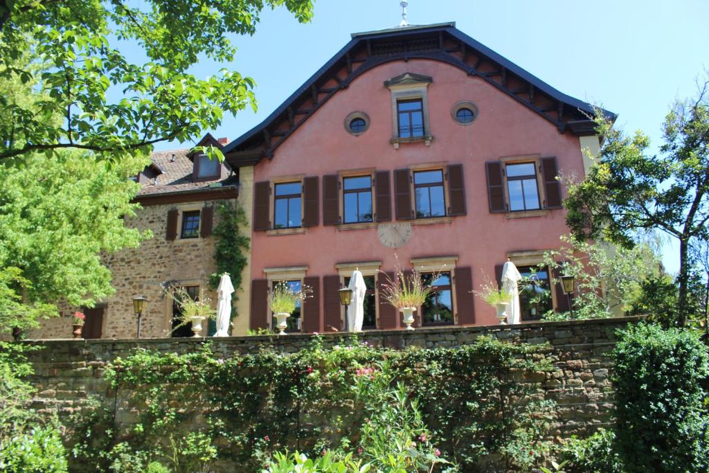 ein altes Haus mit Pflanzen an einer Backsteinmauer in der Unterkunft Schloss Deidesheim in Deidesheim
