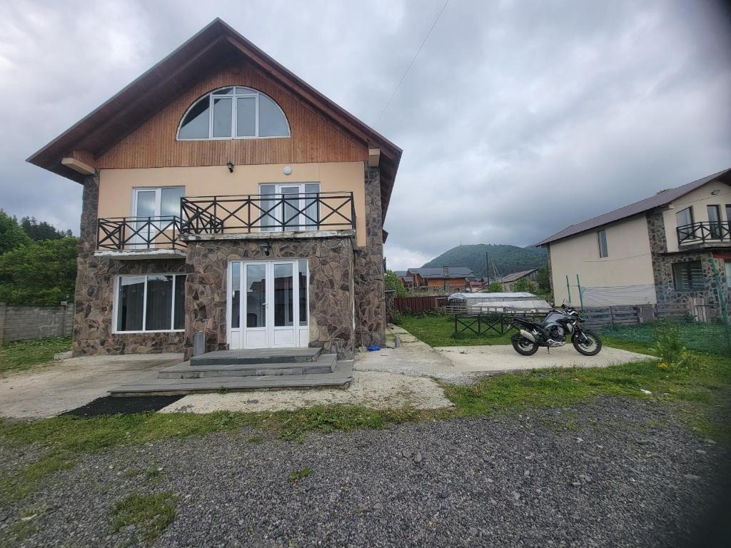 a house with a motorcycle parked in front of it at Cottage in Bakuriani