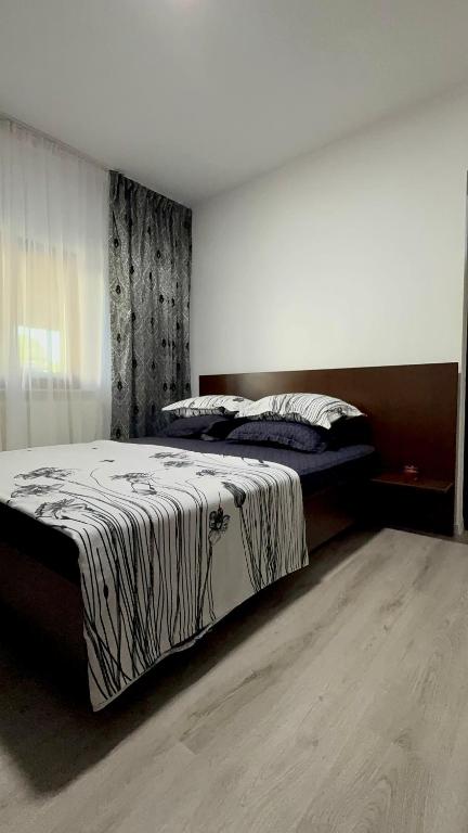a bedroom with a bed with a striped comforter at Alexander Home in Techirghiol