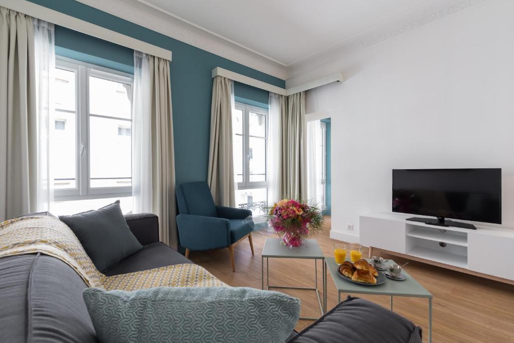 - un salon avec un canapé et une télévision dans l'établissement Florella Antibes Apartment, à Cannes