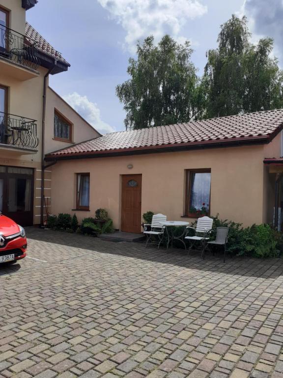 a house with a patio and a table and chairs at Przystanek Dąbki in Dąbki