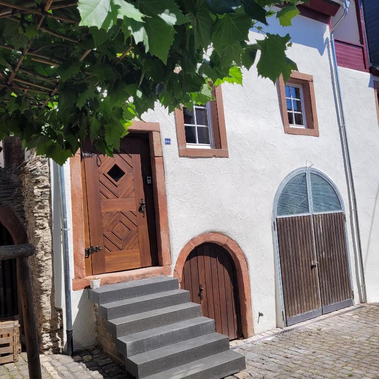 a building with a wooden door and stairs at Scheune Am alten Posthof Lieser in Lieser