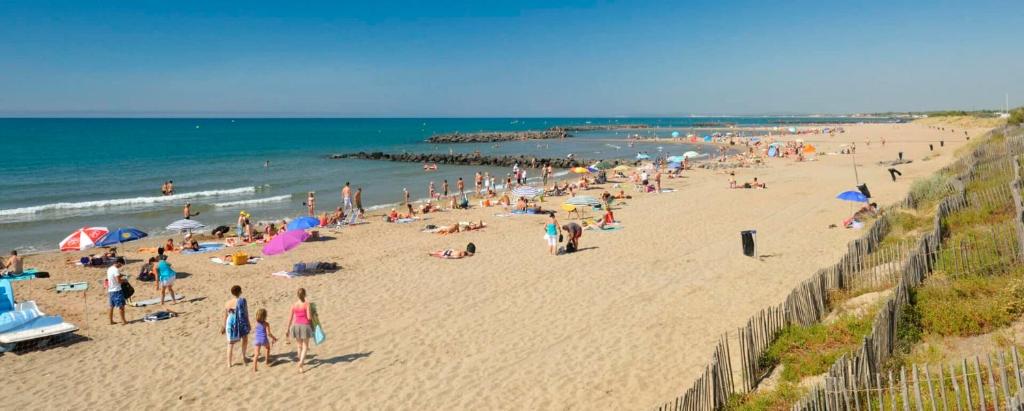 Une foule de gens sur une plage avec l'océan dans l'établissement Confortable Appartement 211 direct access to sea 3min, 2 parking free, à Vias