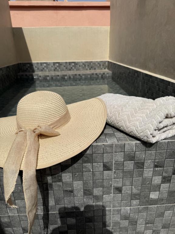 un cappello di paglia appoggiato su un pavimento piastrellato di Riad Le Marrakech Berrima a Marrakech