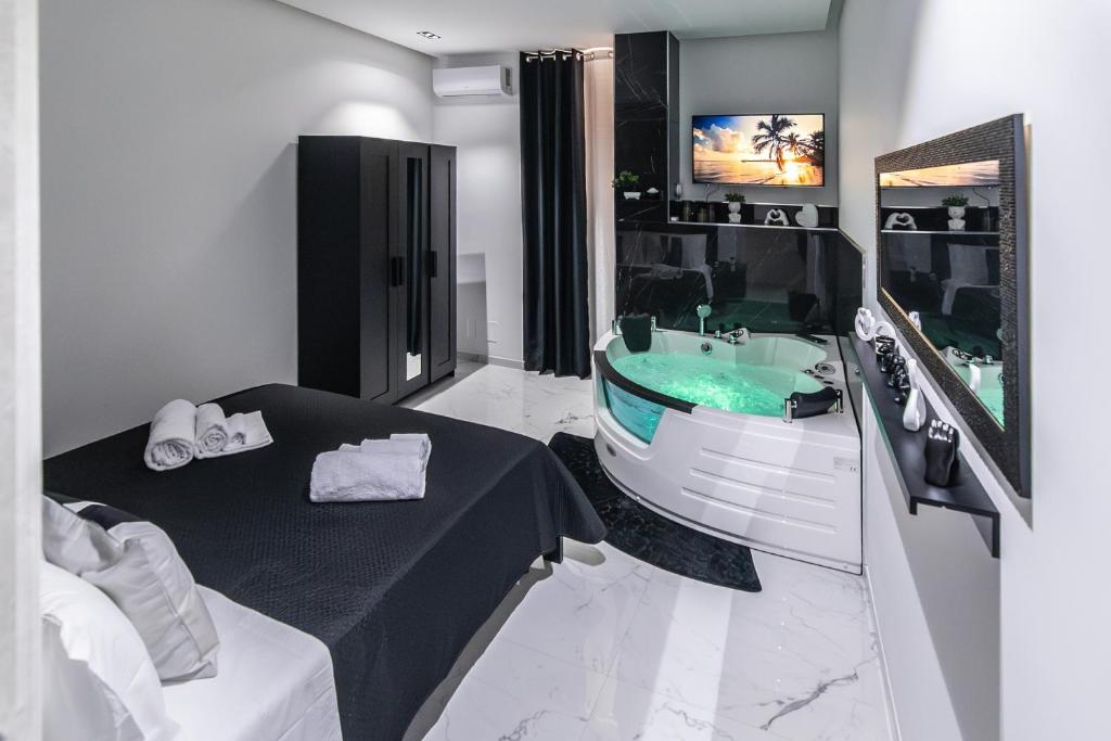 a bathroom with a bath tub and a sink at Amour - House with Private Jacuzzi in Rosolini