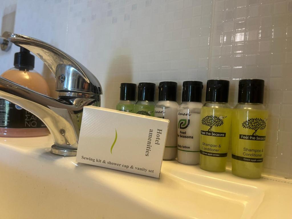 a sink with several bottles of cleaning products next to a faucet at Maniatis Garden in Achladies