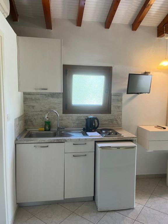 a kitchen with a sink and a tv on the wall at Maniatis Garden in Achladies