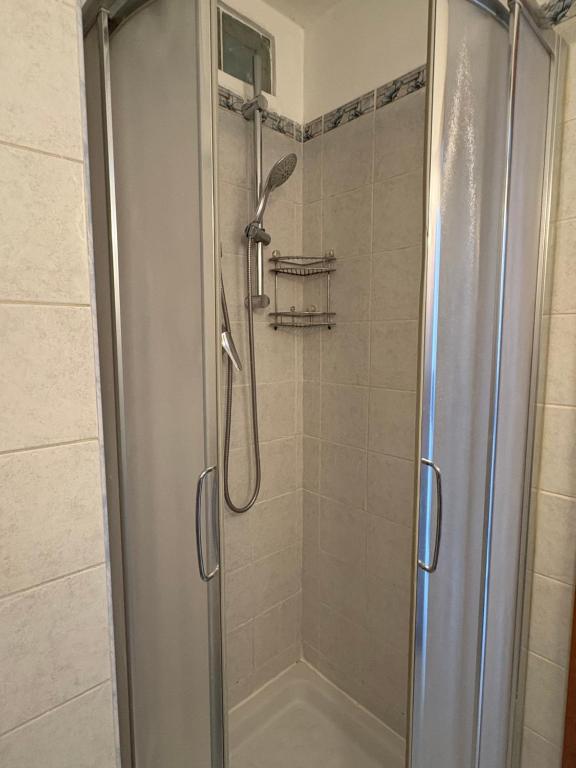 a shower with a glass door in a bathroom at Blue House in Turin
