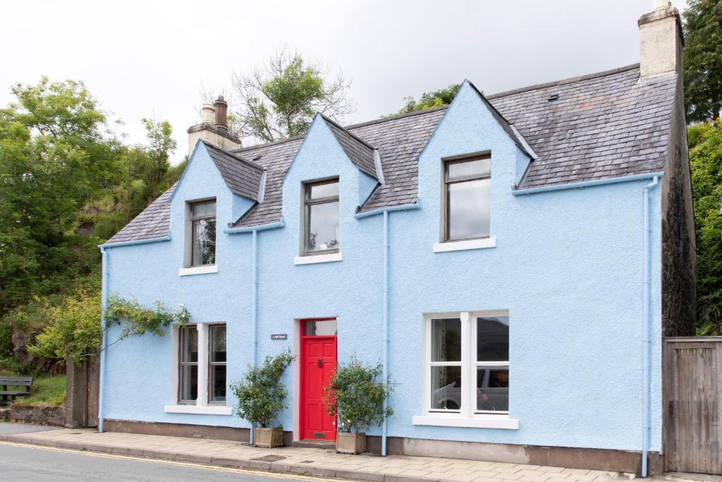 a blue house with a red door at The Blue House in Portree
