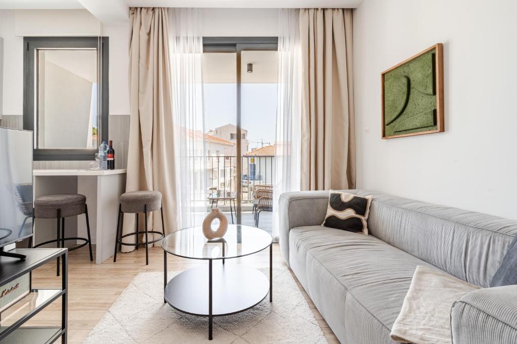 a living room with a couch and a table at Yamas Urban Living Olympia Suites in Limassol