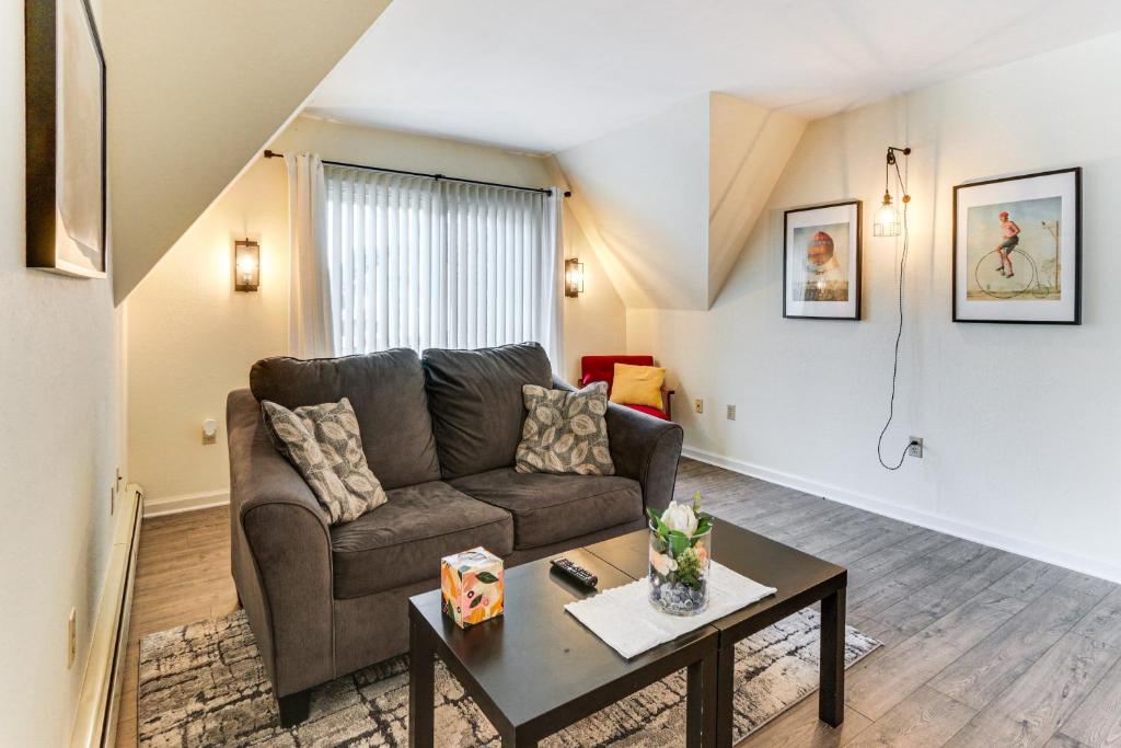 a living room with a couch and a table at Walk to Town Charming Unit with Balcony in Bedford! in Bedford