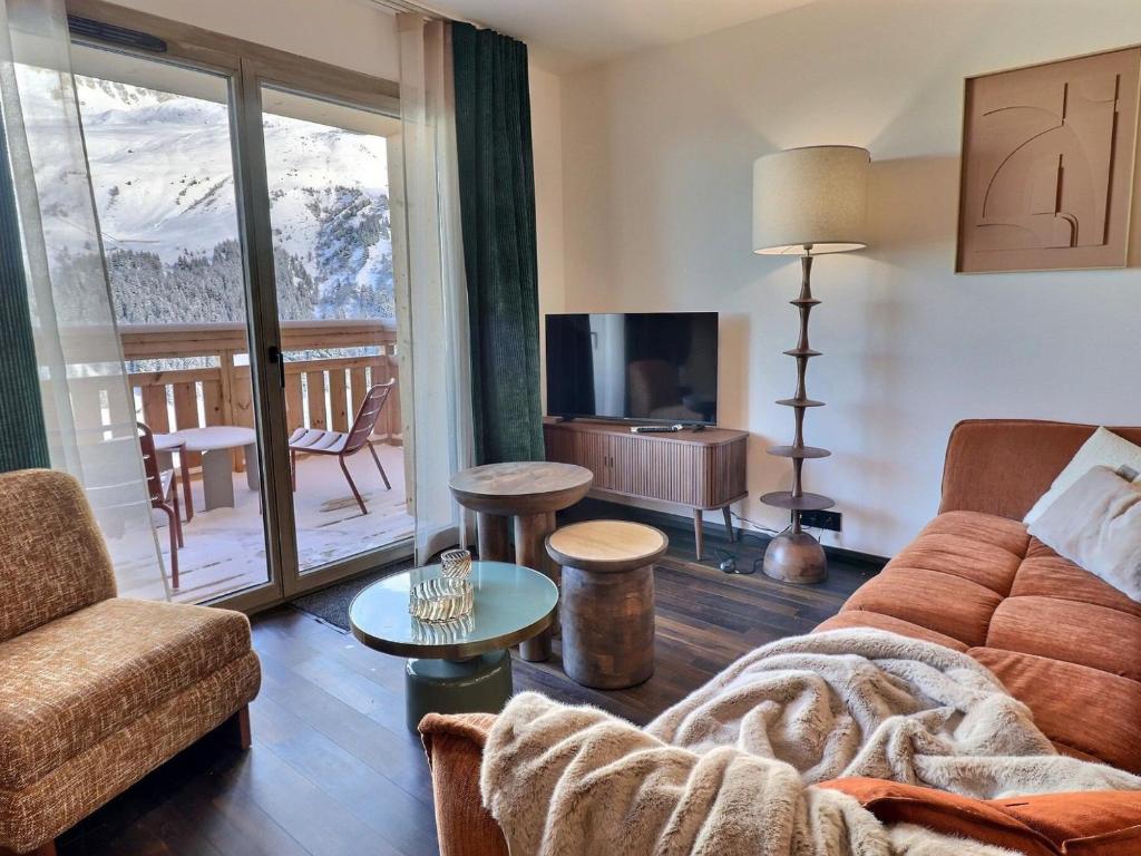 un salon avec un canapé et une télévision dans l'établissement 3 pièces cabine moderne - Proche pistes & commerces, parking inclus, non-fumeur - FR-1-182-262, à Les Allues